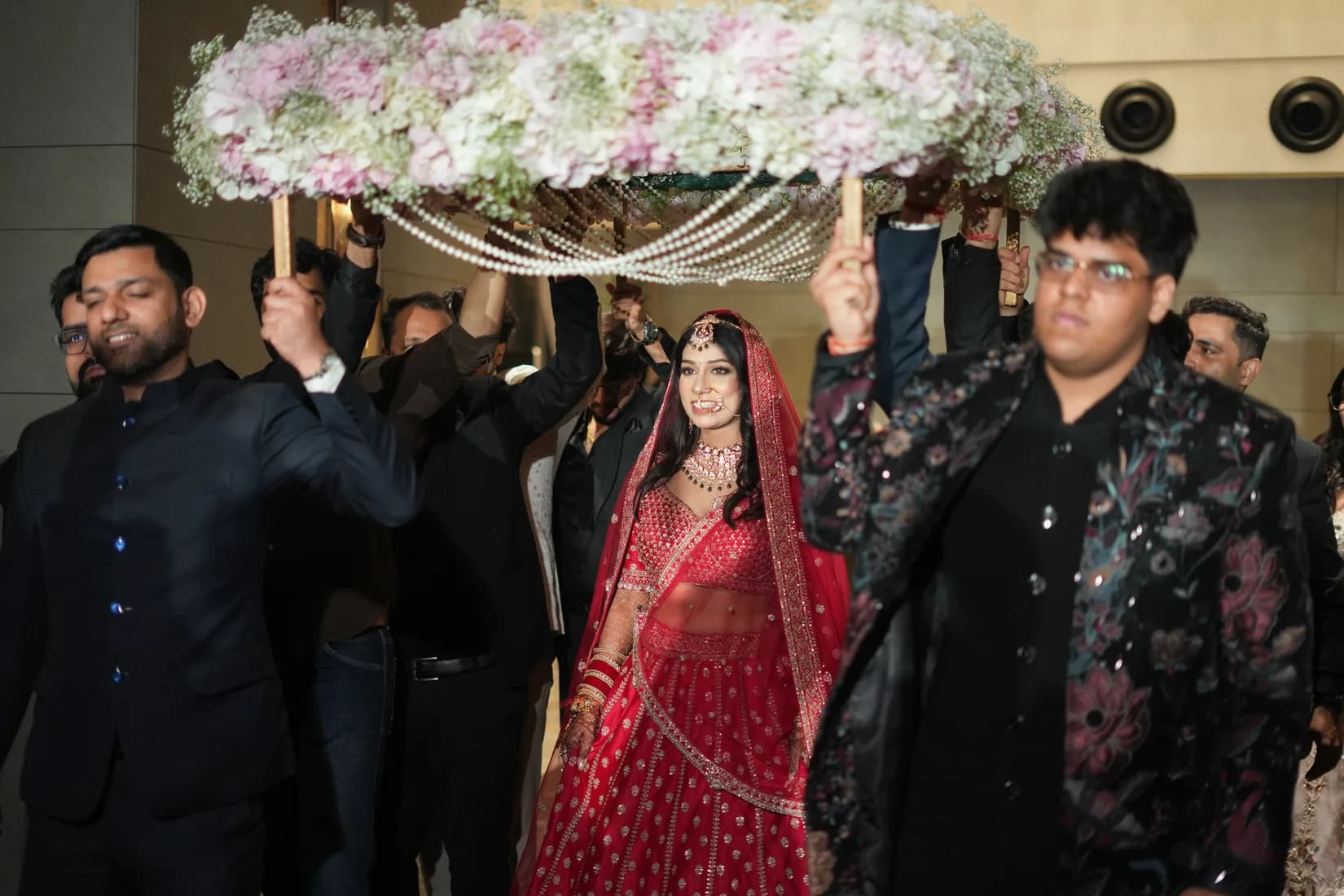 Extended family dancing at Punjabi wedding celebration, bright traditional clothes, joyful expressions mid-dance
