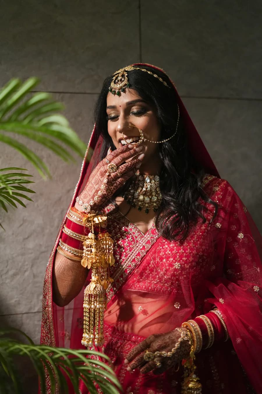 Rajasthani bride in red lehenga with heavy gold jewellery in desert light