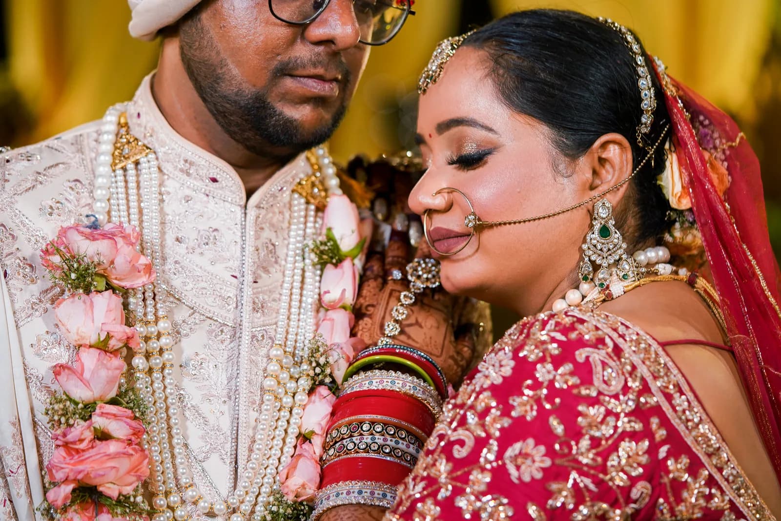 Bride in Lucknowi sharara with traditional jewellery at an ornate haveli or heritage venue in Lucknow with warm evening lighting
