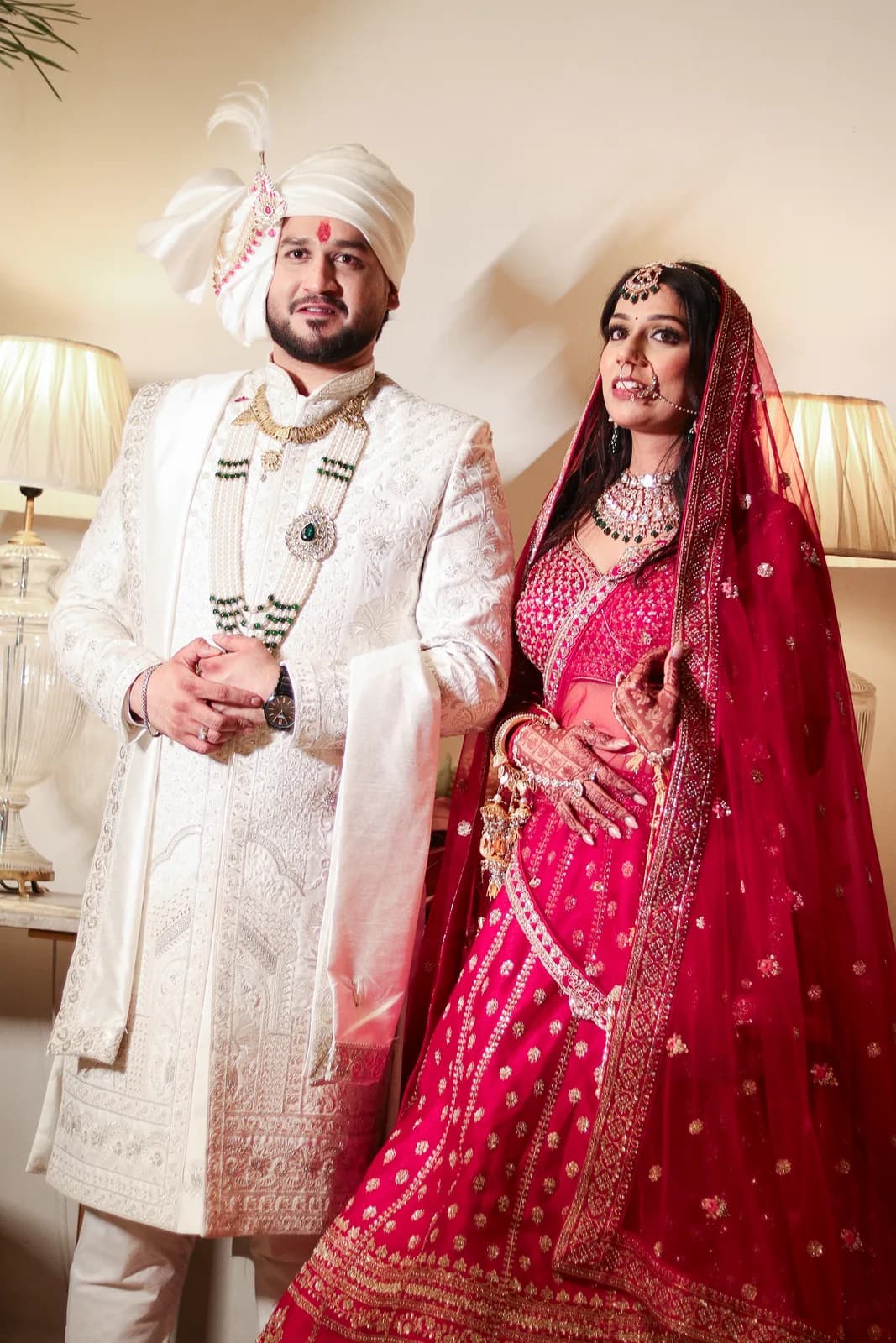 Groom in white sherwani with bride in red lehenga — candid wedding photography by Lens9 Studio, New Delhi