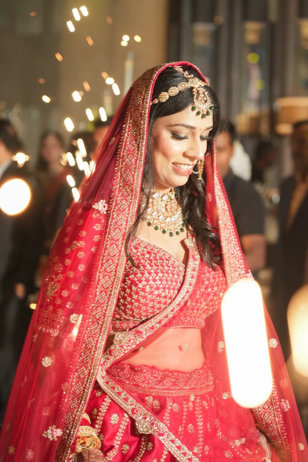 Bride in red lehenga amid sparklers — cinematic wedding moment by Lens9 Studio, New Delhi