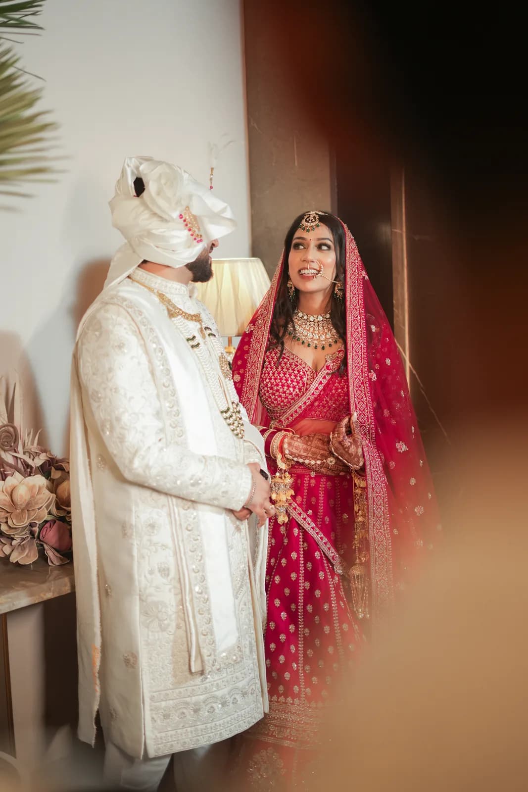 Couple in white and red wedding attire — cinematic wedding photography, Lens9 Studio, New Delhi